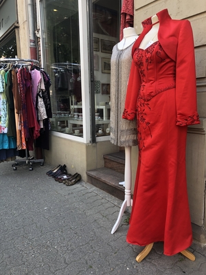 Rotes Abendkleid auf einer Puppe vor einem Secon-Hand-lLaden